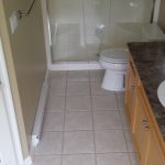 Bathroom renovation with new shower insert, cabinets, tile flooring.